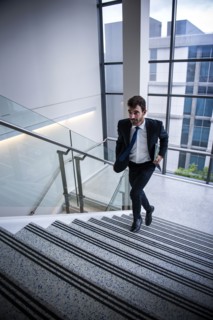 Hispanic businessman running on staircase