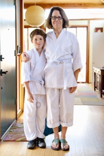 Portrait of Caucasian mother and son wearing martial arts clothing