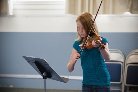 Caucasian girl practicing violin