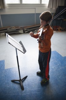 Caucasian boy practicing violin