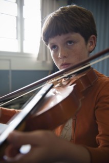 Close up of Caucasian boy practicing violin