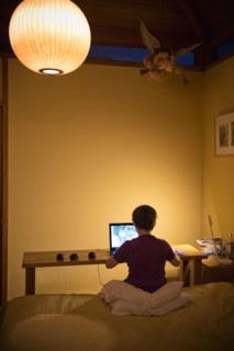 Caucasian boy sitting on bed using laptop