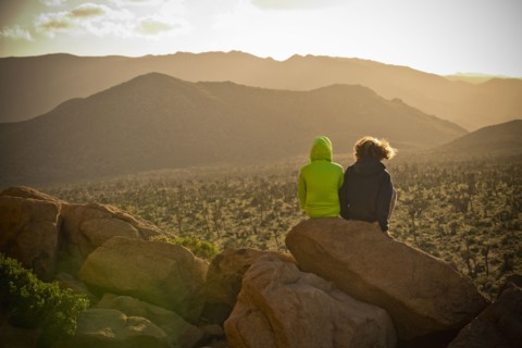 Boys sitting on rock admiring desert landscape