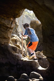 Caucasian boy hiking on rocks