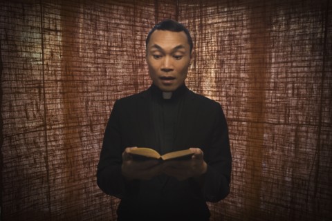 Pacific Islander priest reading bible