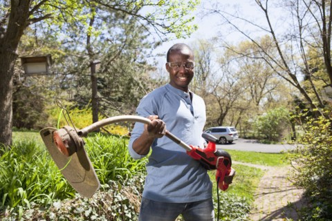 Black man holding weed trimmer