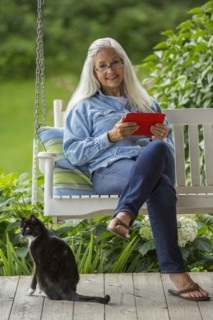 Caucasian woman using digital tablet on porch swing
