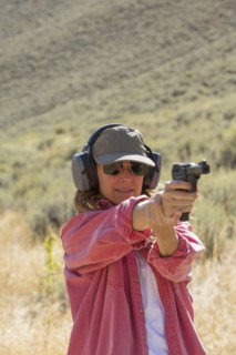 Caucasian woman aiming gun outdoors