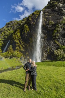 Caucasian couple hugging near remote waterfall
