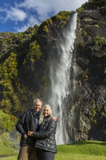 Caucasian couple hugging near remote waterfall