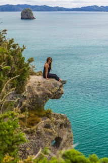Caucasian hiker sitting on coastal cliff