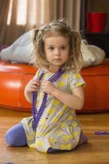 Caucasian preschooler girl playing dress-up with necklace