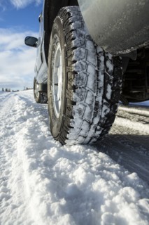 Close up of car tires driving in snow