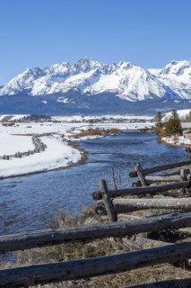 Snowy mountains and river in rural landscape