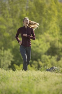 Caucasian woman running on hill