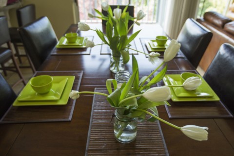 Wilting flowers in jar on dining table