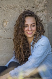 Caucasian woman sitting at concrete wall