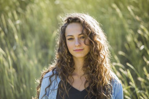 Caucasian woman standing in field of tall grass