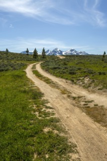 Winding dirt road near snow covered mountain range