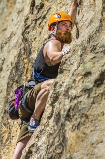 Caucasian man climbing rock