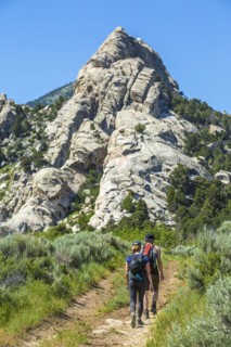 Caucasian couple hiking toward mountain