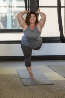 Woman performing yoga hanging from silks