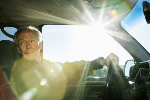 Caucasian man driving car looking back