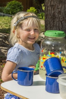 Smiling Caucasian girl selling lemonade