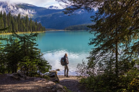 Caucasian man standing at mountain lake