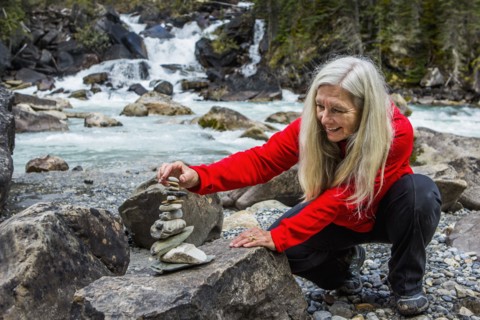 Caucasian woman balancing stack of rocks