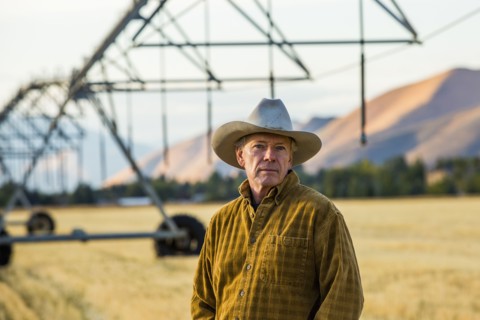 Caucasian farmer standing near irrigation equipment