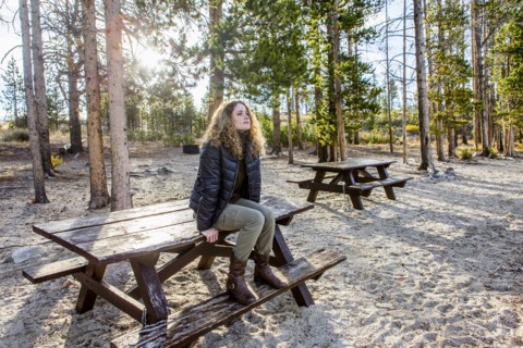 Caucasian woman sitting on picnic table