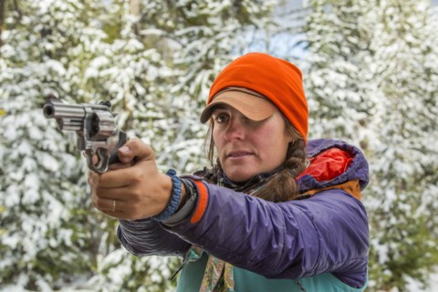 Caucasian woman aiming handgun in winter
