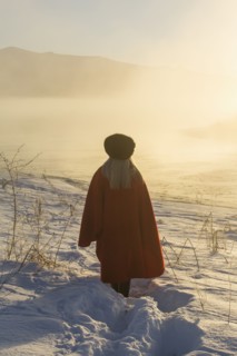 Caucasian woman standing in winter landscape at sunset