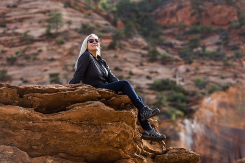 Caucasian woman sitting on edge of rock