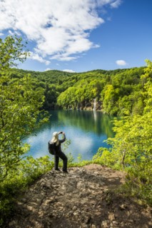 Older Caucasian woman photographing waterfall with cell phone