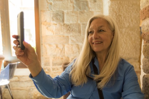 Older Caucasian woman posing for cell phone selfie