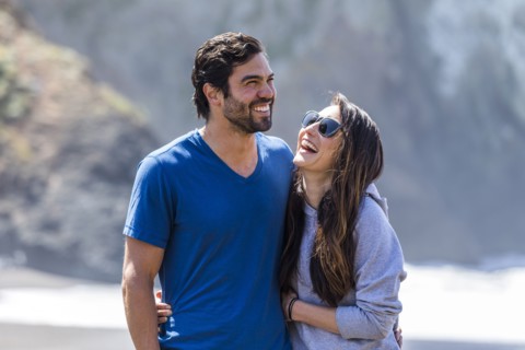 Couple laughing and hugging on beach