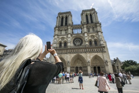 Caucasian woman photographing building