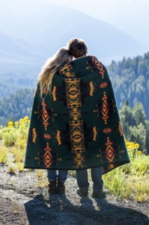 Caucasian couple wrapped in blanket admiring scenic view of landscape
