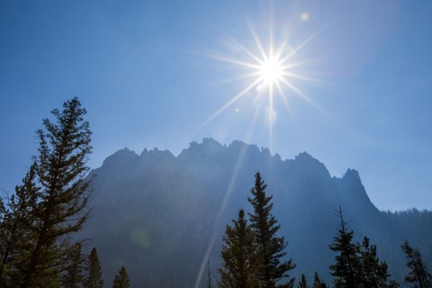 Sunbeams over trees near mountain
