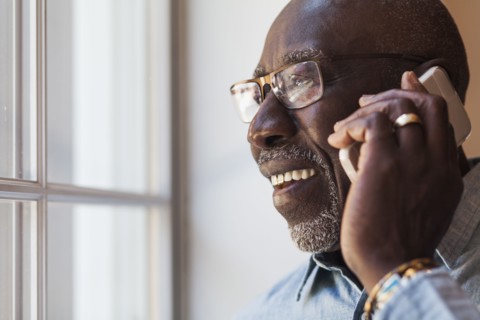 Man talking on cell phone near window