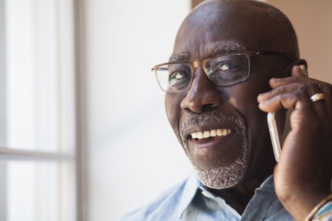 Man talking on cell phone near window