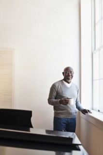 Man drinking coffee near window