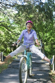 Caucasian woman sitting on bicycle with legs apart