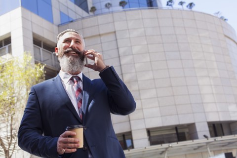 Caucasian businessman talking on cell phone outdoors