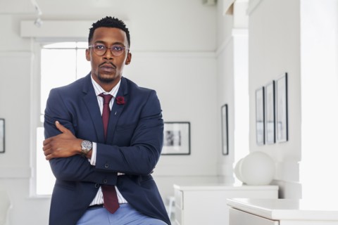 Black man with arms crossed in gallery