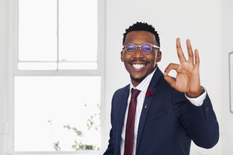 Black man gesturing okay in gallery