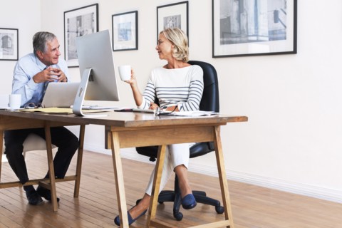Caucasian businessman and businesswoman talking at table