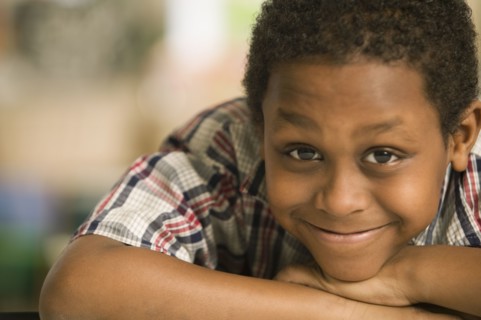 African boy laying head on arms